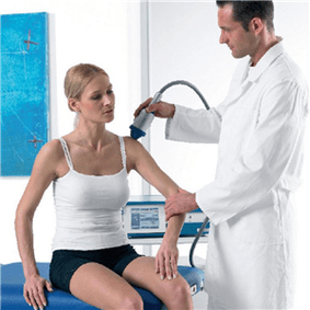 Medicul efectuează tratamentul osteochondrozei la o femeie
